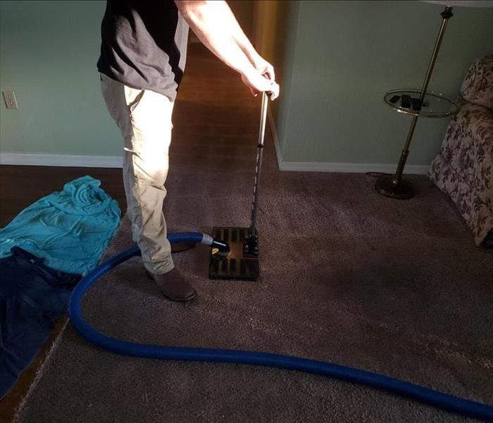 Employee extracting water from carpet.