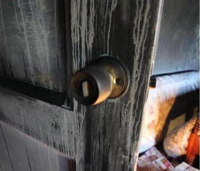 Door knob, door covered with watery soot.